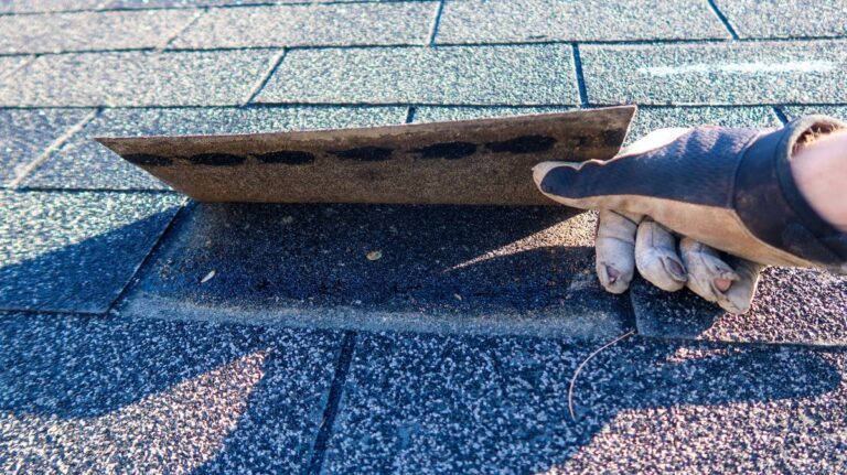 Roof inspection dark glove lifting shingles
