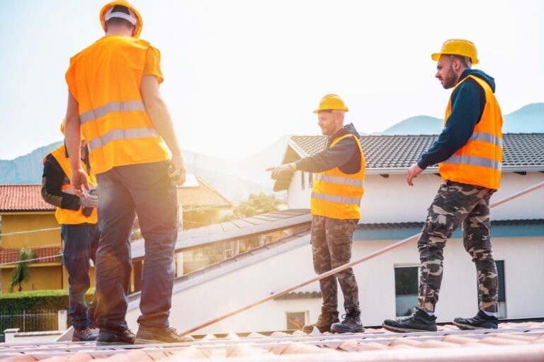 four workers installing roof