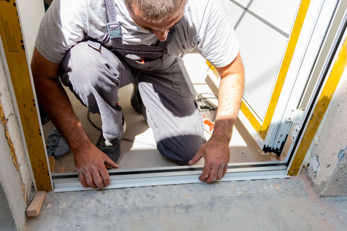 worker installing new door leaning down