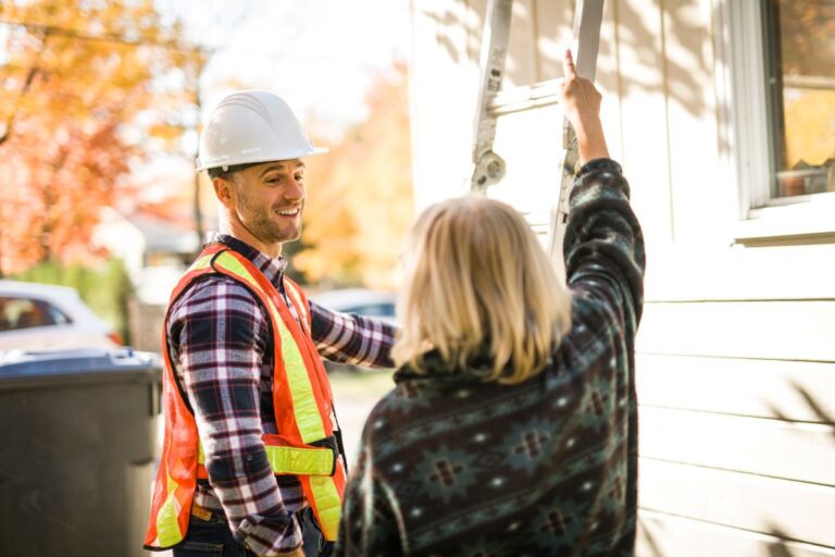worker speaking with client in front of house