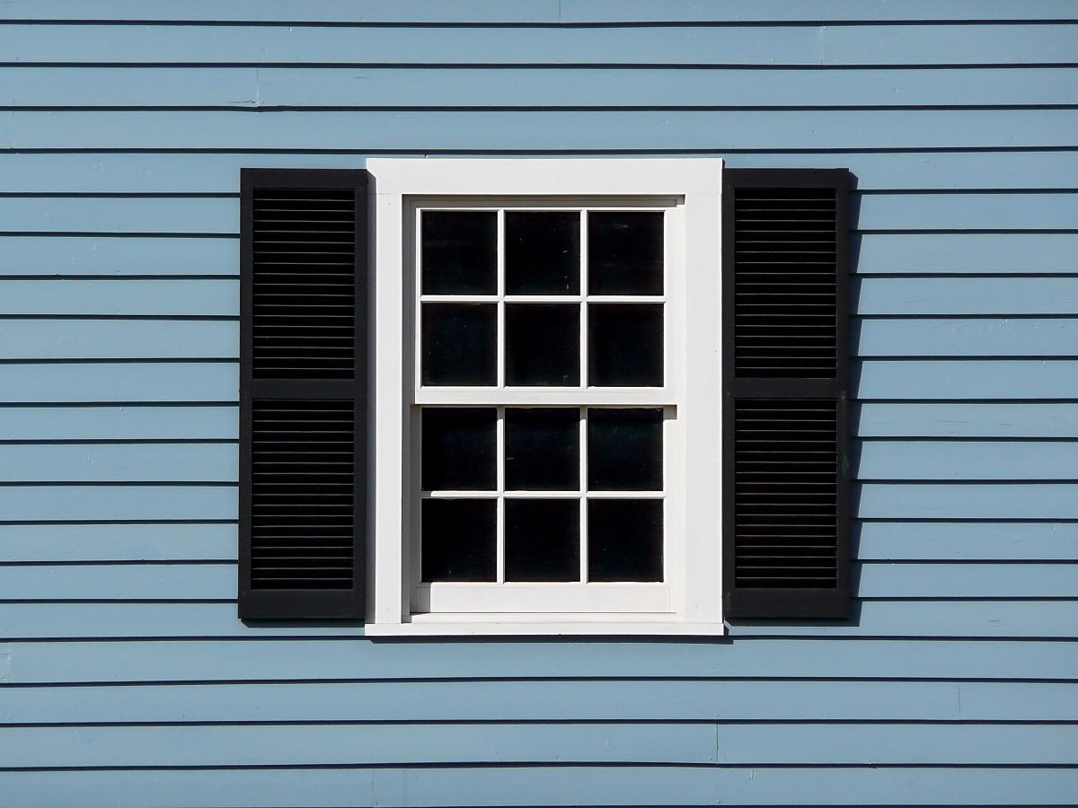 blue house with white window and black accents