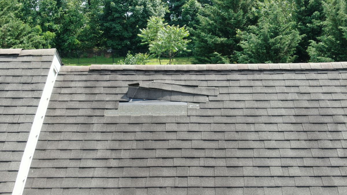 missing shingles light grey shingles roof big house