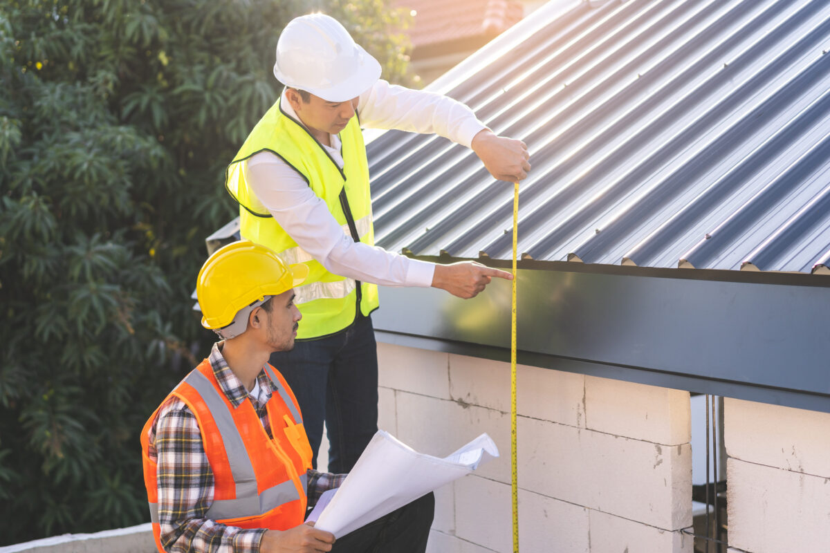 how to measure roof pitch Builder team, foreman house asian young engineer, architect, contractor discussing metal sheet rooftop on blueprint follow project to build industrial plan at outdoor site. Engineering worker people.