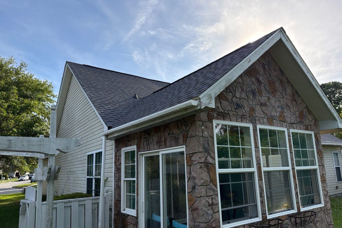 what are eaves small house with dark grey shingles and big windows